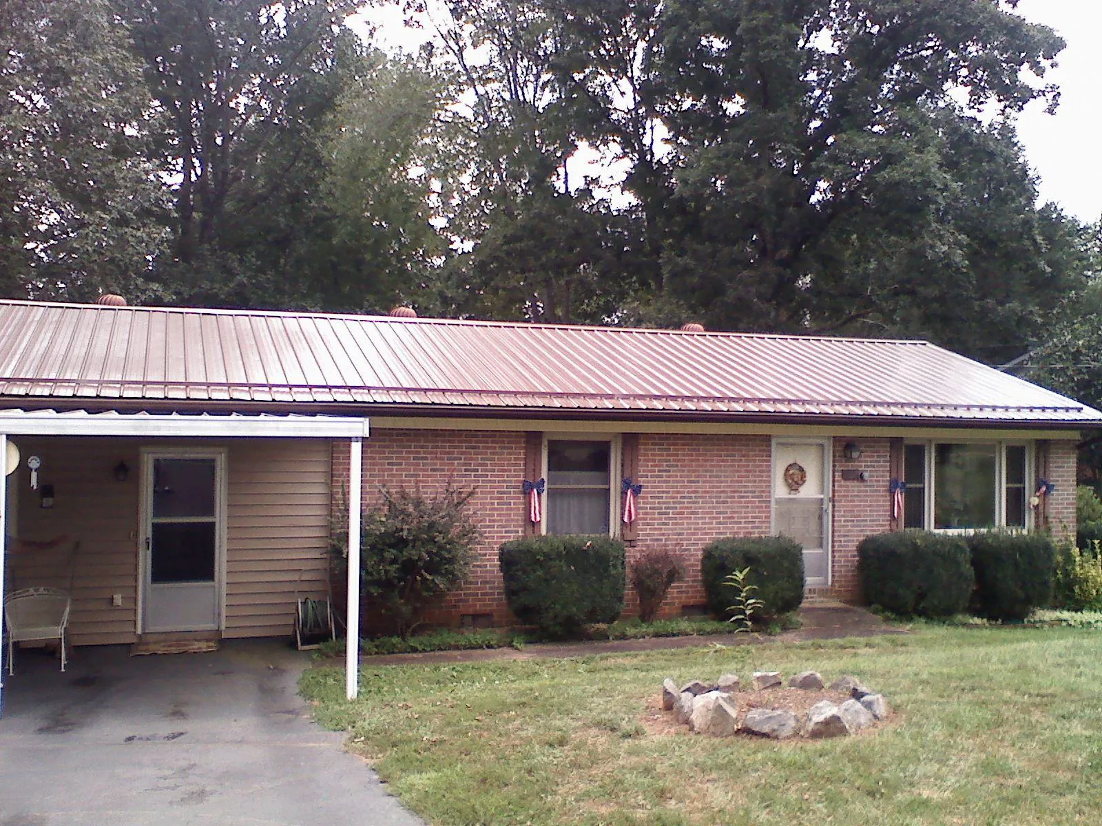 Bronze metal roof and carport on a brick ranch home — Roof Repair work by our crew in Malvern